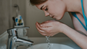 Girl-washing-her-face-with-clean-water-thanks-to-60K-Water-Softener-System-for-Home